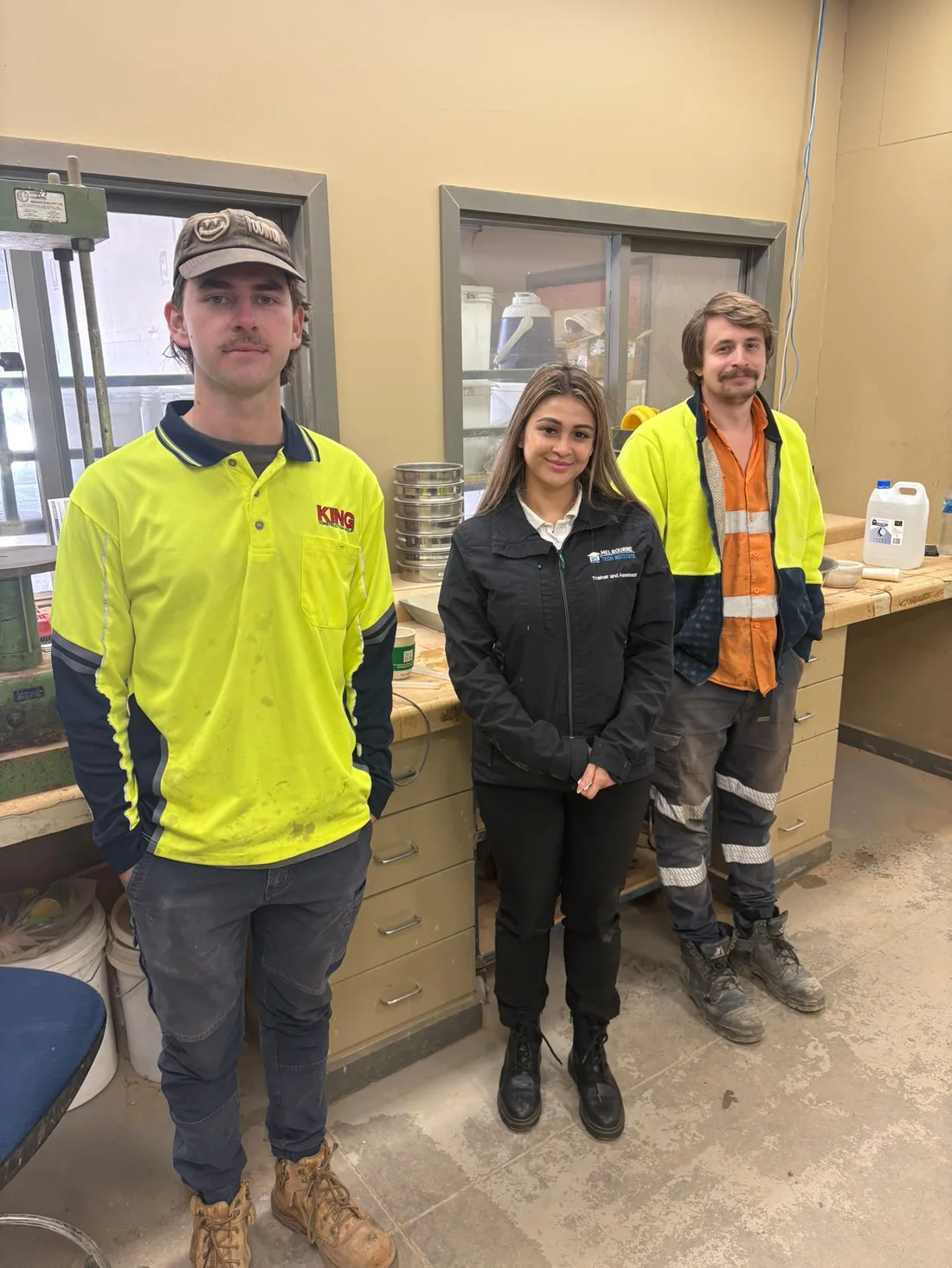 Three Melbourne Tech Institute students in a workplace laboratory during their training